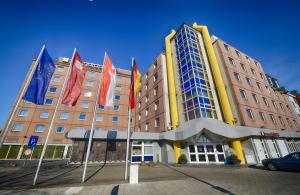 un gran edificio con banderas delante en Leonardo Hotel Köln, en Colonia