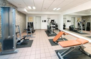 a gym with several treadmills and exercise equipment at Leonardo Hotel Köln in Cologne