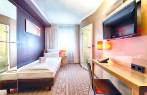 فندق ليوناردو ميونيخ البوتيكي  في ميونخ: غرفة فندقية بسرير وتلفزيون بشاشة مسطحة