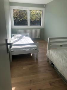 a bedroom with two beds and two windows at Le Colombier in Annecy