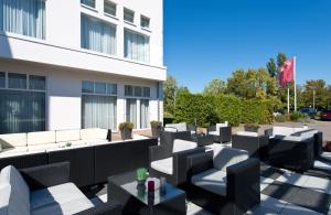 a patio with black and white furniture and a building at Leonardo Hotel Heidelberg in Heidelberg