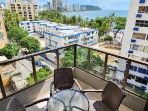 balcón con sillas y vistas a la ciudad en Apartamentos cerca a la playa, Los Laureles - By Bedviajes, en Santa Marta