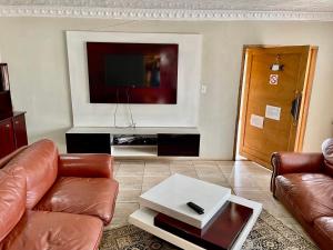 sala de estar con sofá y TV de pantalla plana en SapzRes at Taung en Lethola