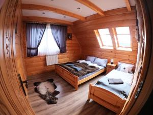 Habitación con 2 camas en una cabaña de madera en Domki z widokiem na Tatry en Bańska