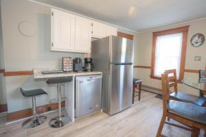 a kitchen with a stainless steel refrigerator and a table at Sunnyside home near Sunday River, Black Mountain, Lakes and Hikes in Rumford