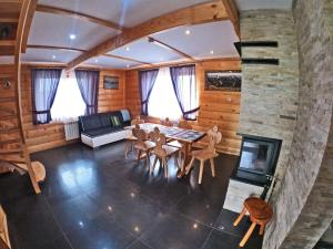 a living room with a table and chairs and a fireplace at Domki z widokiem na Tatry in Bańska