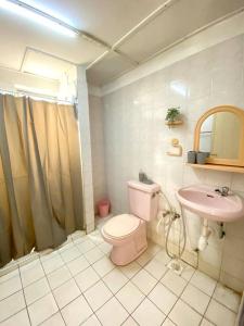 a bathroom with a pink toilet and a sink at The Nest - Cozy 3-Bedroom Condo with Pool in Shah Alam