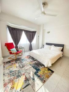 - une chambre avec un grand lit et une chaise rouge dans l'établissement The Nest - Cozy 3-Bedroom Condo with Pool, à Shah Alam