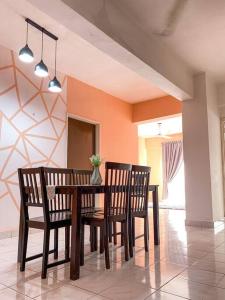 a dining room with a wooden table and chairs at The Nest - Cozy 3-Bedroom Condo with Pool in Shah Alam