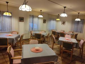 a dining room with tables and chairs and lights at Auf dem roten Fels in Eppenbrunn