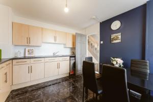 a kitchen with wooden cabinets and a table with chairs at Langdon Park DLR beds to stay in London