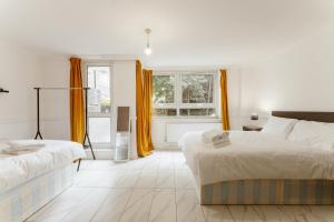 biała sypialnia z 2 łóżkami i oknem w obiekcie Langdon Park DLR beds to stay w Londynie
