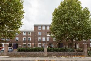 un bâtiment en briques avec des arbres devant lui dans l'établissement Langdon Park DLR beds to stay, à Londres