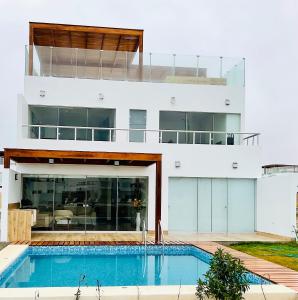 a house with a swimming pool in front of it at Solymar Beach House - Paracas in Paracas