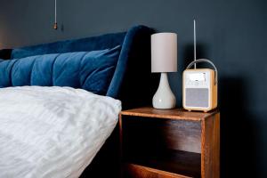 a bed with a blue couch and a lamp on a table at Charming Victorian Townhouse Near Oxford in Witney