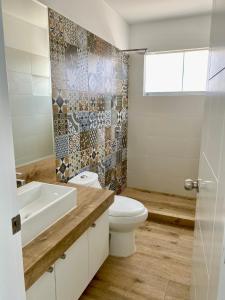 a bathroom with a toilet and a sink at Solymar Beach House - Paracas in Paracas