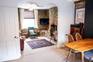 a living room with a table and a fireplace at Charming Victorian Townhouse Near Oxford in Witney