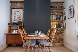 a dining room with a wooden table and chairs at Charming Victorian Townhouse Near Oxford in Witney