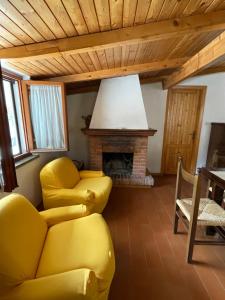 salon z żółtą kanapą i kominkiem w obiekcie Discovering Apartments Abetone w mieście Abetone