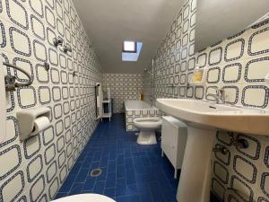 łazienka z 2 umywalkami, toaletą i wanną w obiekcie Discovering Apartments Abetone w mieście Abetone +23 zdjęcia
