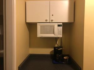 a small kitchen with a microwave and a cupboard at Island Travel Inn in Victoria