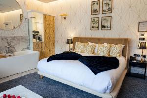 a bedroom with a large bed and a bath tub at The Spa Hotel in Royal Tunbridge Wells