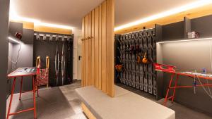 a room with a wall of hockey equipment at Natura Boutique Chalet Wellness SPA in Dobbiaco