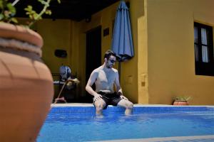 a man sitting in the water in a swimming pool at Finca La Majadera in El Rosario