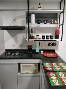 a kitchen with a stove and a microwave on a counter at Apartamento em Nova Betânia - West Flat Mossoró in Mossoró