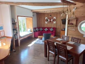 Cabañas Chaya Mapu في بويرتو آيسن: غرفة معيشة مع طاولة وأريكة حمراء