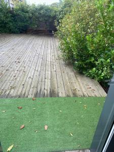 una terrazza in legno con prato verde di IBI ENJOY le petit a Ligné