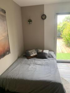 ein Bett in einem Schlafzimmer mit einem großen Fenster in der Unterkunft IBI ENJOY le petit in Ligné