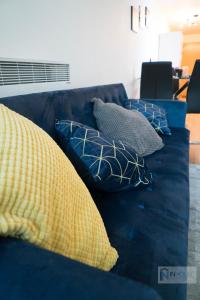 Un sofá azul con cuatro almohadas. en Modern City centre apartment WIFI Netflix en Nottingham