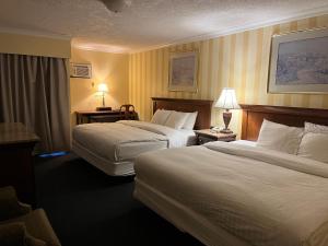 a hotel room with two beds and two lamps at Island Travel Inn in Victoria