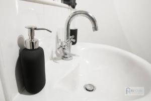 lavabo con dispensador de jabón junto a un grifo en Modern City centre apartment WIFI Netflix en Nottingham