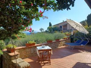 a patio with a table and chairs and an umbrella at CASA MARGOT(RELAX CON VISTA) in Arenella