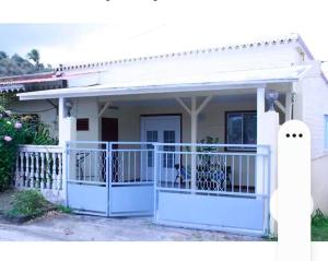a house with a blue gate and a fence at Maison de 2 chambres avec jardin clos et wifi a Le Vauclin a 6 km de la plage in Le Vauclin