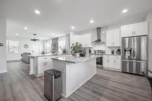 a large kitchen with white cabinets and a large island at New Construction Located in Ybor City! in Tampa