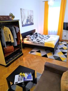 a living room with a bed and a dresser and a room with at D16 Apartman in Szentgotthárd