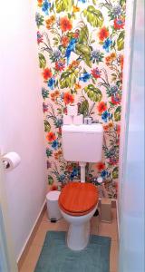 a bathroom with a toilet with a floral wallpaper at D16 Apartman in Szentgotthárd