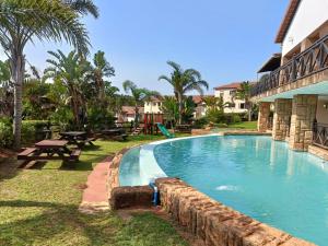 a swimming pool in a resort with a picnic table at Ocean View Villas F16 Port Edward in Port Edward