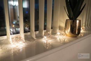 a window sill with christmas lights and a vase on it at Modern City centre apartment WIFI Netflix in Nottingham
