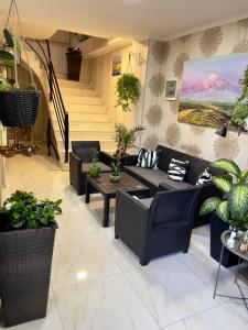 a living room with couches and tables and potted plants at Hotel Marioni in Tbilisi City