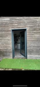 una puerta abierta de un edificio con un patio de césped en IBI ENJOY le petit, en Ligné