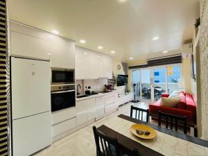 a kitchen with white cabinets and a table in a room at Atlantic Coast Apartment - Playa Del Inglés in Playa del Ingles