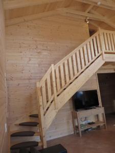 eine Treppe in einem Blockhaus mit einem TV in der Unterkunft EifelGlückVII in Rieden