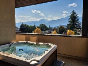 uma banheira de hidromassagem numa varanda com vista para as montanhas em Alpenglow Penthouse by Revelstoke Vacations em Revelstoke