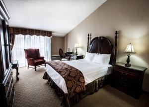 une chambre d'hôtel avec un lit et une chaise dans l'établissement Old Stone Inn Boutique Hotel, à Niagara Falls