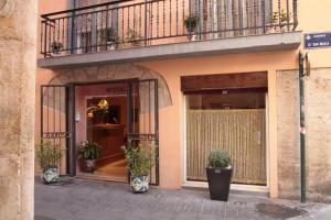 a building with a balcony and a door with potted plants at Hostal Antigua Morellana in Valencia +18 photos