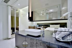 a bathroom with a sink on a counter with a bed at Golden Hotel Incheon in Incheon